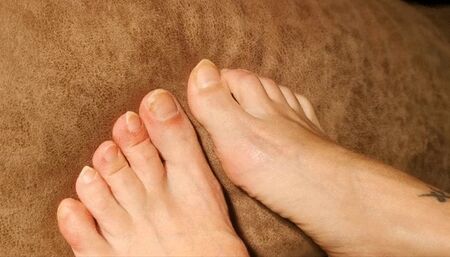 Pointy long natural toenails scratching fabric and hand's skin