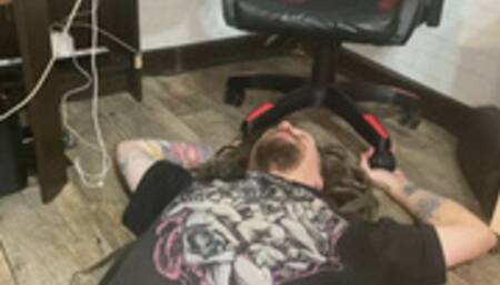 Human footstool with his hands under chair wheels and hands trampling in high heels