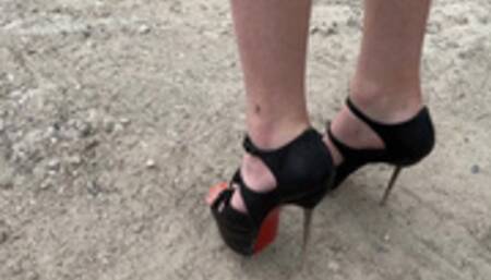 a girl in high heels pierces plastic, wood, bottles and other objects with her sharp heels