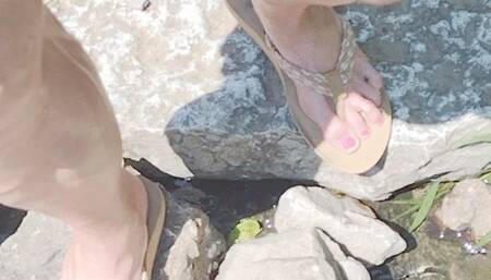 In tan flip flops walking and flexing