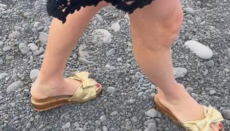 gold old vintage sandals sank deep into the salty rocky beach she almost fell in freezing water with strong waves