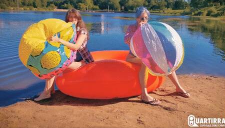 Q886 Cosette and Stashia blow two big beach balls on a lake - 1080p