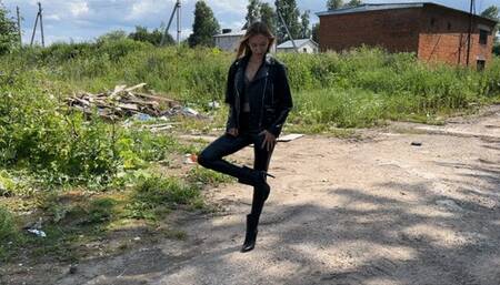 girl in leather boots with high heels walks through the mud