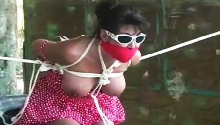 Tethered with rope in the hot sun wearing sundress pantyhose sunglasses and ballet flats