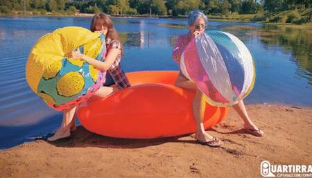 Q886 Cosette and Stashia blow two big beach balls on a lake - 1080p