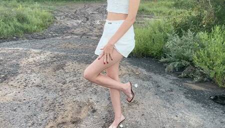 girl in high heel sandals walks through the mud, gets her toes dirty, her shoes, mud is too slippery