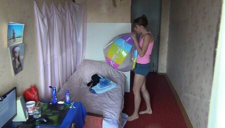Svetlana is in a hurry to inflate a beach ball