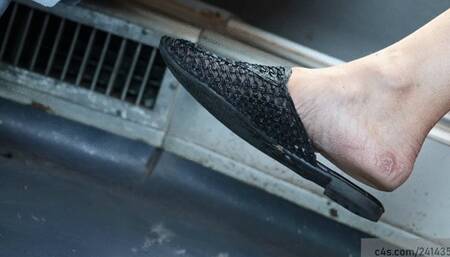 candid dangling dirty feet with slippers moving the foot nervously