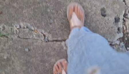 Flipflops walking stepping on plastic bottle