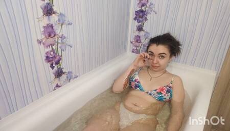 Hottie squishing her belly while lying in the bathtub