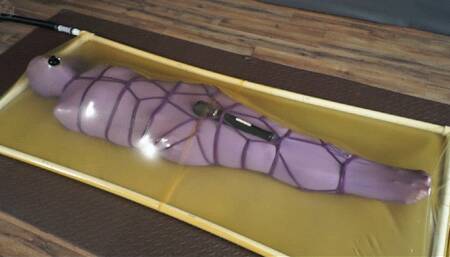 Lilac nylon cocoon and lilac rope bondage with vibro in a latex bed