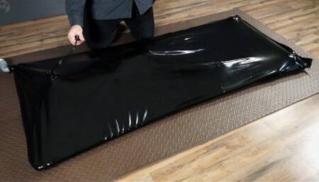 Rope bondage with pear gag in a black latex bed