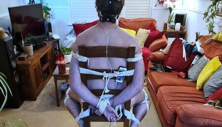 Gloved handjob on naked man tied to chair