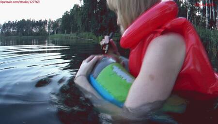 Alla swims on an inflatable ring in the lake and POPs it with a stick and wears a red inflatable vest on her naked body!!!