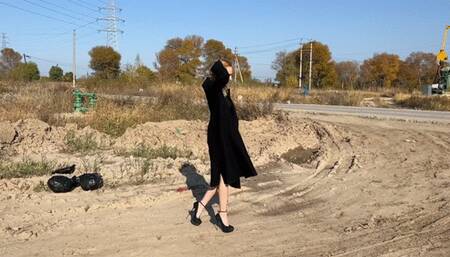 girl in high heels crushes two watermelons with her heels, making holes in them and standing on them