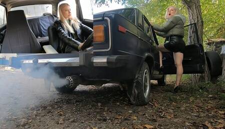 Two blondes makes exhaust fumes to the guy behind the car