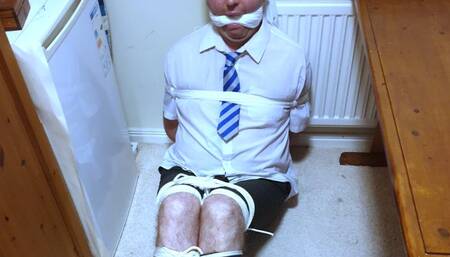 Tightly bound and gagged man in adult school uniform kept in room