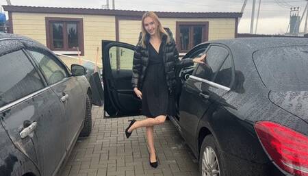 girl in a car plays with her feet in nylon tights