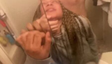 Blasian bent over bathroom sink while roommates in other room