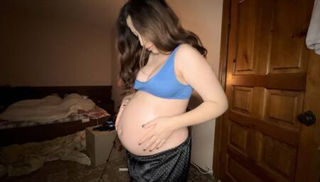 a pregnant woman anoints her tummy with oil from stretch marks