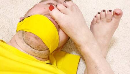 Miss M feet in her bound victims face as she edges him