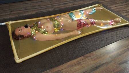 Bondage with tinsel and garland in latex vacuum bed with vibro