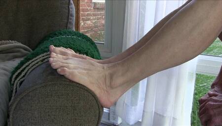 Lilly, her bare feet up on the arm of the couch