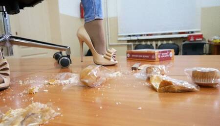Rocking hottie crushes a pile of food on the table with her beautiful legs in high heel pums