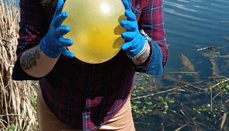 girl in gloves blowtopop balloon on nature
