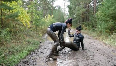 Two leather-clad hotties wrestling in the mud
