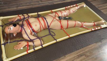 Bondage with ropes to the frame in latex bed with vibro