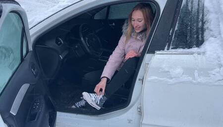 girl in the cold cannot start the car, the car only makes the sound of a starter, and the girl presses the pedals with her bare feet
