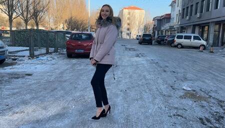 girl decided to walk to the store in high-heeled shoes, but the whole road was covered in ice, her heels were slipping a lot