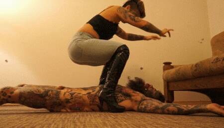 BRUTAL STOMACH SITTING PUNISHMENT WEARING ROUGH JEANS AND DOMINATRIX BOOTS