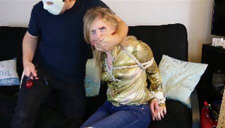 Dresden wearing a shiny golden blouse and jeans is a cowgirl held for ransom, cleave gagged and then ballgagged