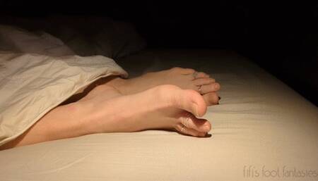 Fifi laying down with feet sticking out from the covers