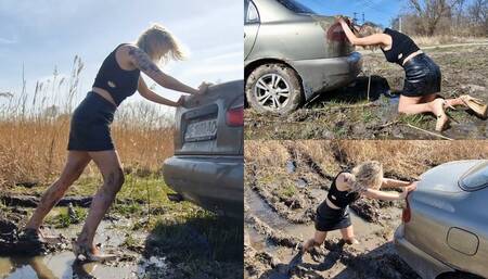 Anastasia desperately pushes the car out of the mud