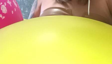 girl poping small foil disney balloons with needle