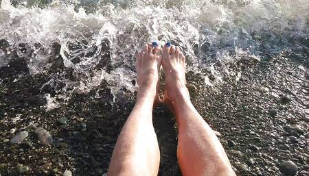 On Public Beach I Sit on the Shore Wearing Shorts and T-shirt and Wetting My Feet in the Sea...
