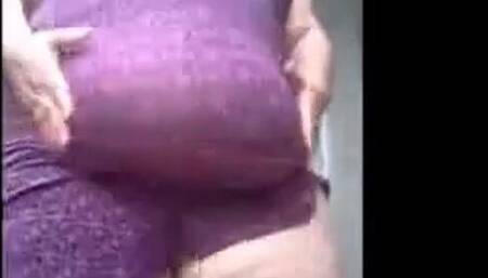 SSBBW in a purple dress plays with her giant belly