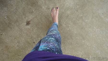 Fifi driving barefoot in leggings with navy blue polish