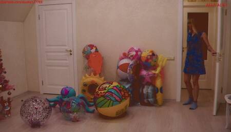 Alla blows off a lot of inflatable toys, squeezing them with her hands with a loud hissing of the air valves