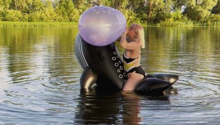 Alla inflates a 16-inch balloon with her mouth, which unexpectedly bursts, and rides on an inflatable whale