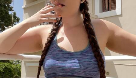 Smoking on the balcony, jean shorts and a sports bra, hair in braids - Smokingrapunzel