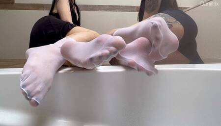 Daniitrix and priifee showing nylon stockings on their legs and applying oil