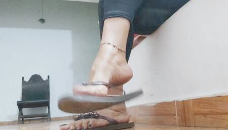 Flip-flops that hang from Angeline's feet as she plays with her toes (1)