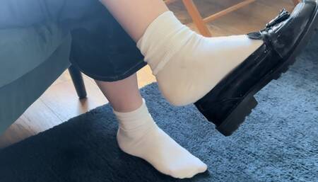 Dangling in white ankle socks and patent black flat loafers