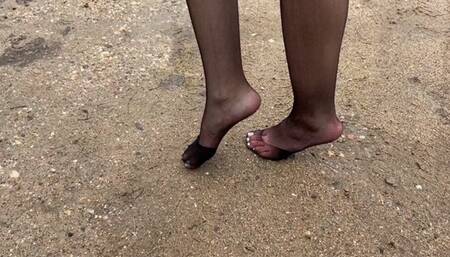 Girl in nylon stockings with pedicure she walks through the mud and the ground, her stockings start to tear and in the end she tramples them into the mud