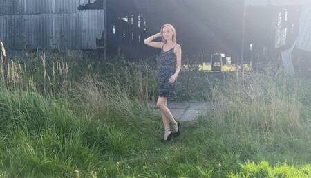 A girl in high-heeled shoes he walks through a landfill with garbage and steps on different garbage