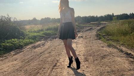 A girl in high-heeled boots walks off-road and stumbles upon sticky mud in which she bathes her boots, sometimes gets stuck in it